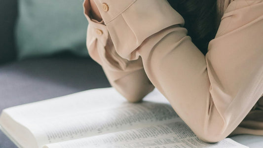 Elbows on open bible, blog post on what is biblical womanhood? The truth every Christian woman needs to know. 