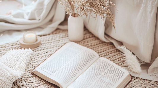 living as a Christian through quiet time with an open bible on the floor next to a candle and vase.