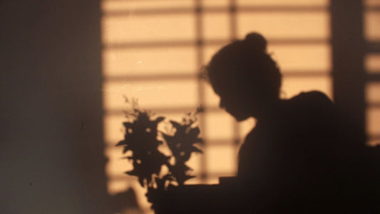 Shadow of a women setting ion the edge of the bed. For a blog post on bible verses for strength when you're tired of holding it all together. 