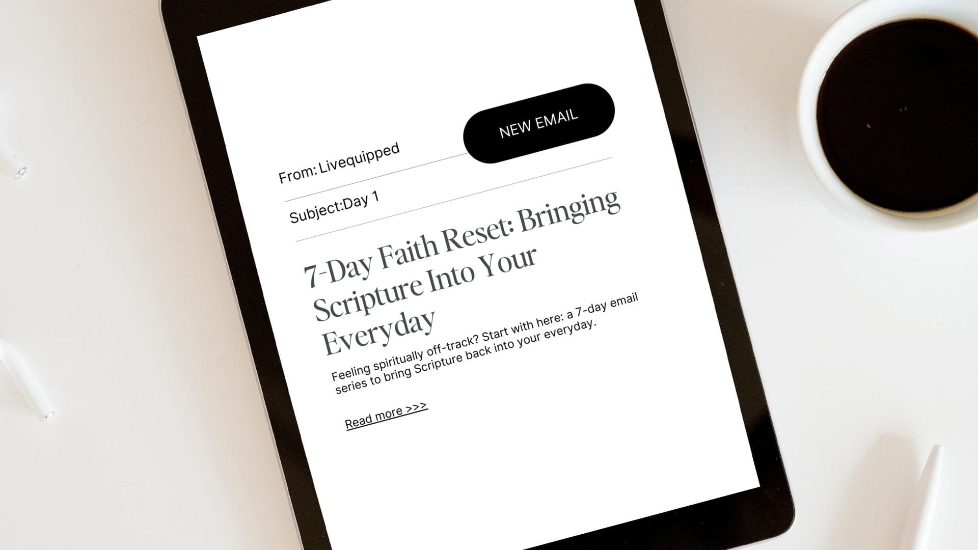 Tablet displaying an email with text on a white surface with a cup of coffee. Sign up for Livequipped's faith reset email series. 